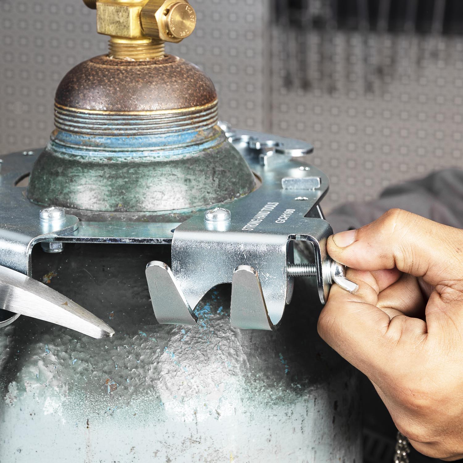 A person using a tool on a gas cylinder valve.