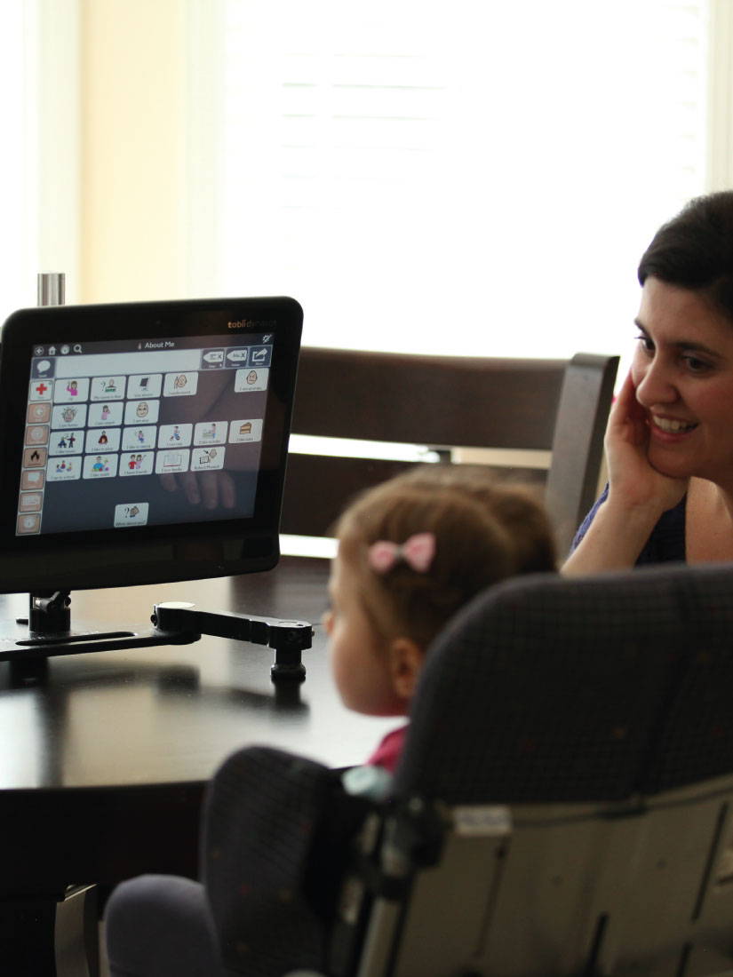 Young girl with Rett syndrome using Tobii Dynavox AAC app and assistive technology to communicate with her mom