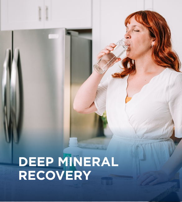 Woman drinking water in kitchen, promoting deep mineral recovery.