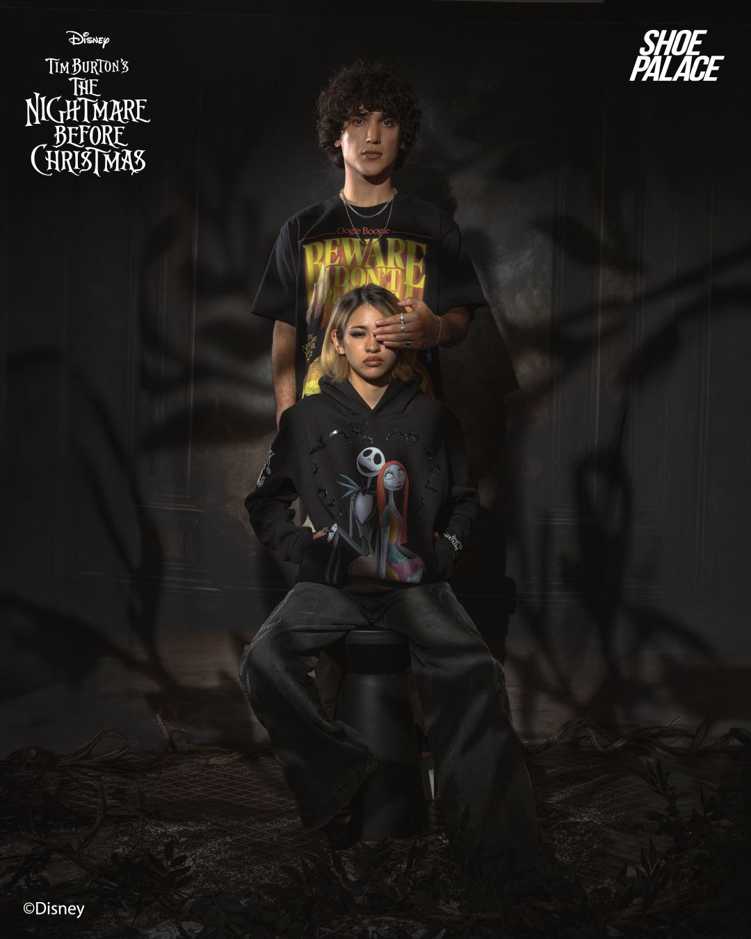 Two people in themed clothing, posing in a dark, artistic setting.