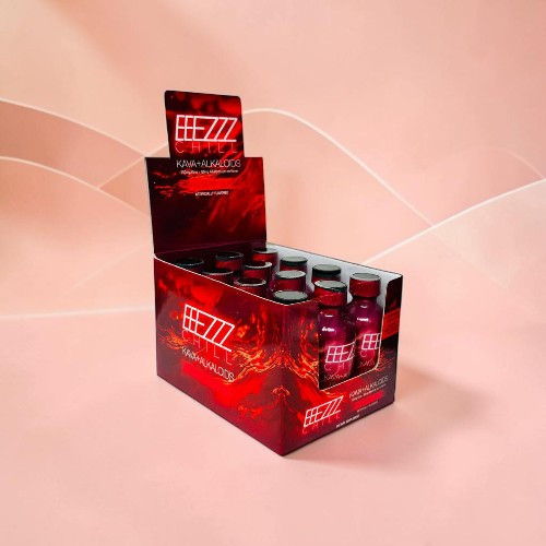 Display box of energy drink bottles with red branding on a pink background.