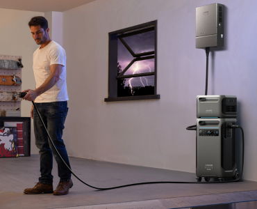 Man using an Anker power station in a room during a storm.