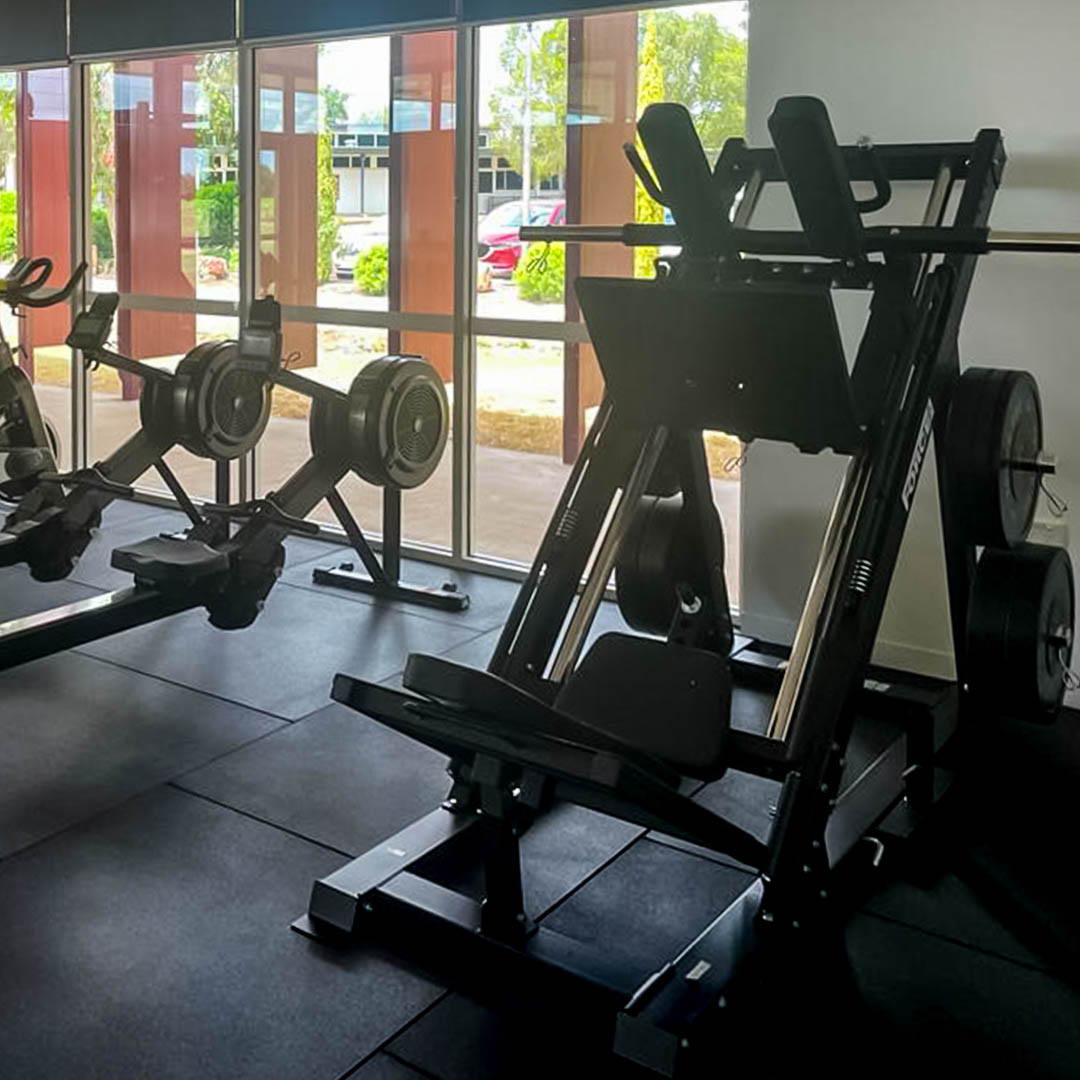 A leg press hack squat machine in a high school gym fit-out, designed for safe and effective lower body strengthening.