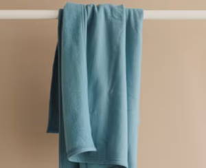 merino fleece blanket hanging on a rack