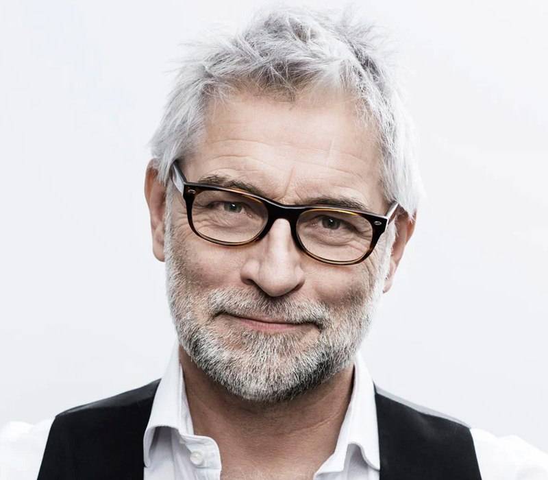 Man with grey hair wearing dark glasses