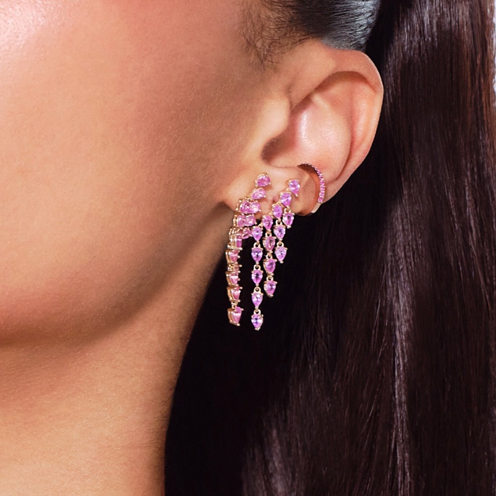 Close-up of a model's ear with stylish pink earrings.