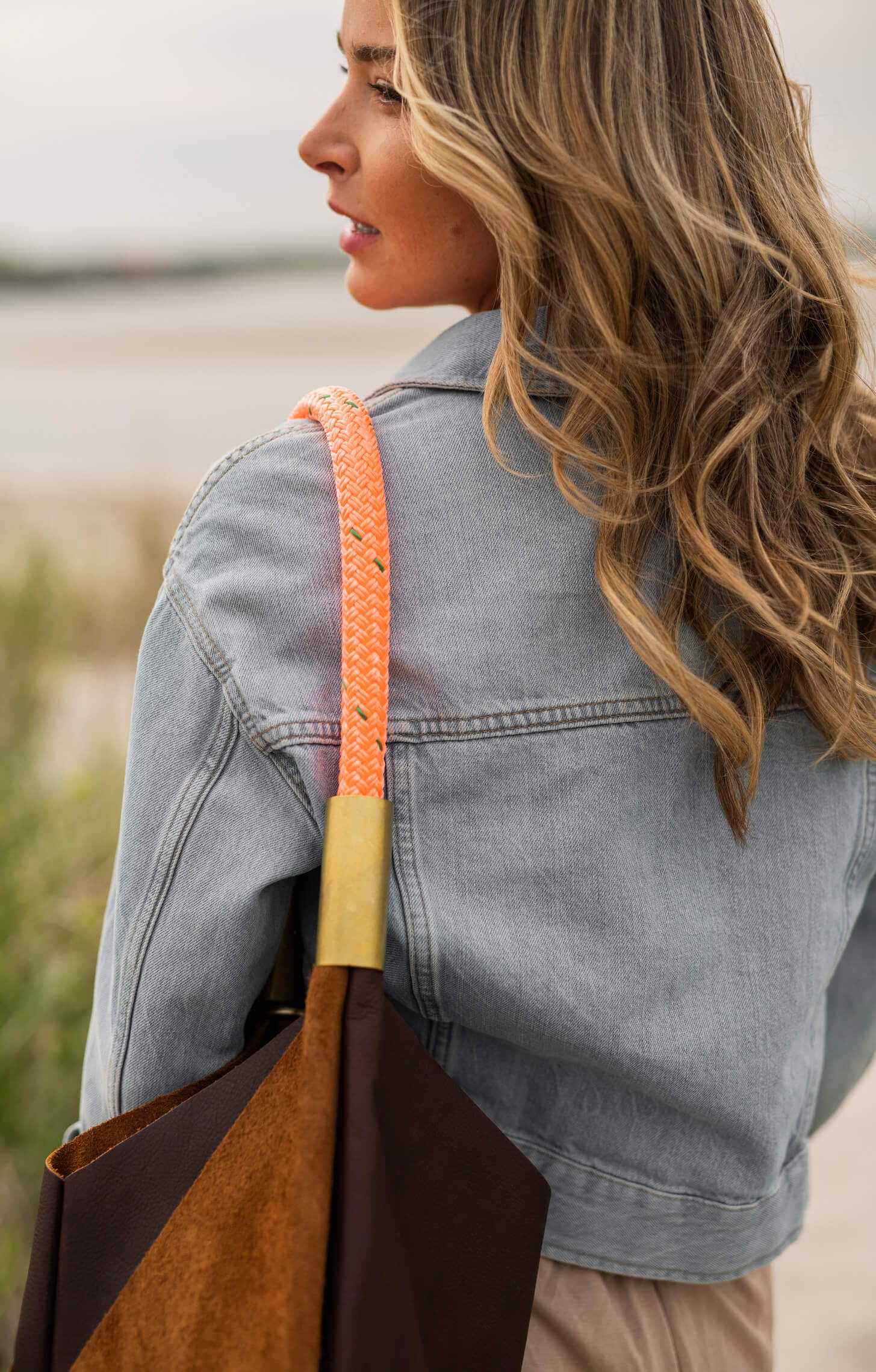 woman wearing brown leather bag with neon orange dock line