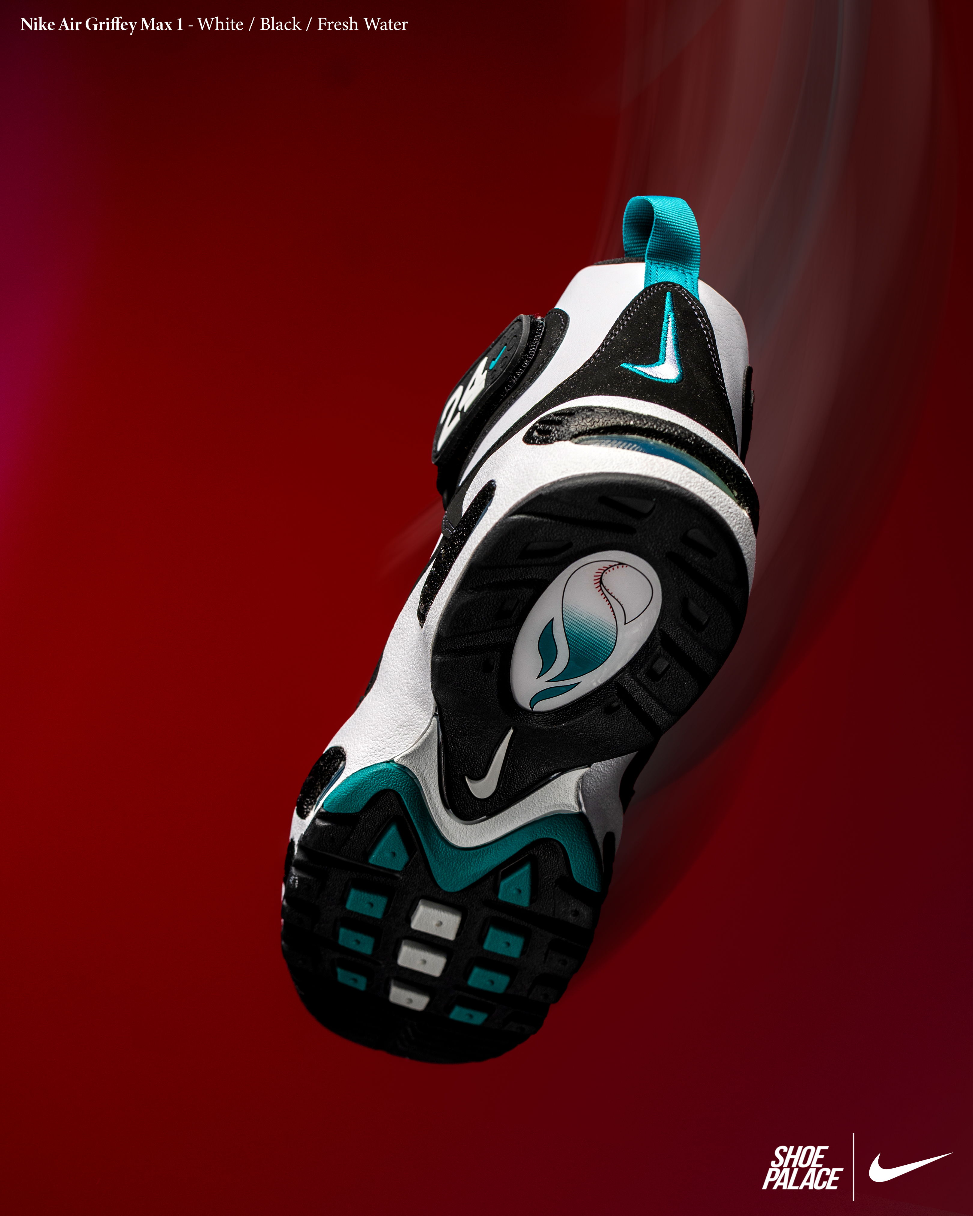 Nike shoe sole with black, white, and turquoise design on a red background.