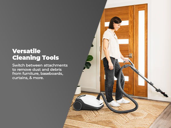 A person using a vacuum cleaner in a home setting.