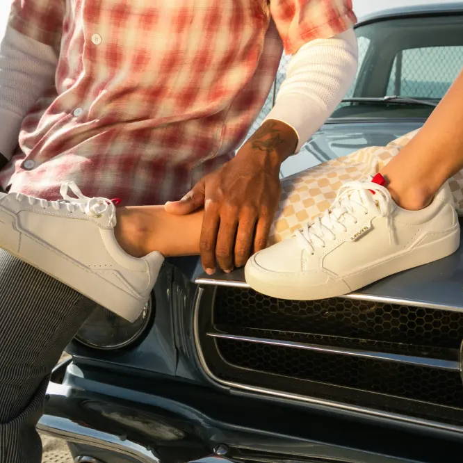 male and female model on hood of car wearing levi's shoes