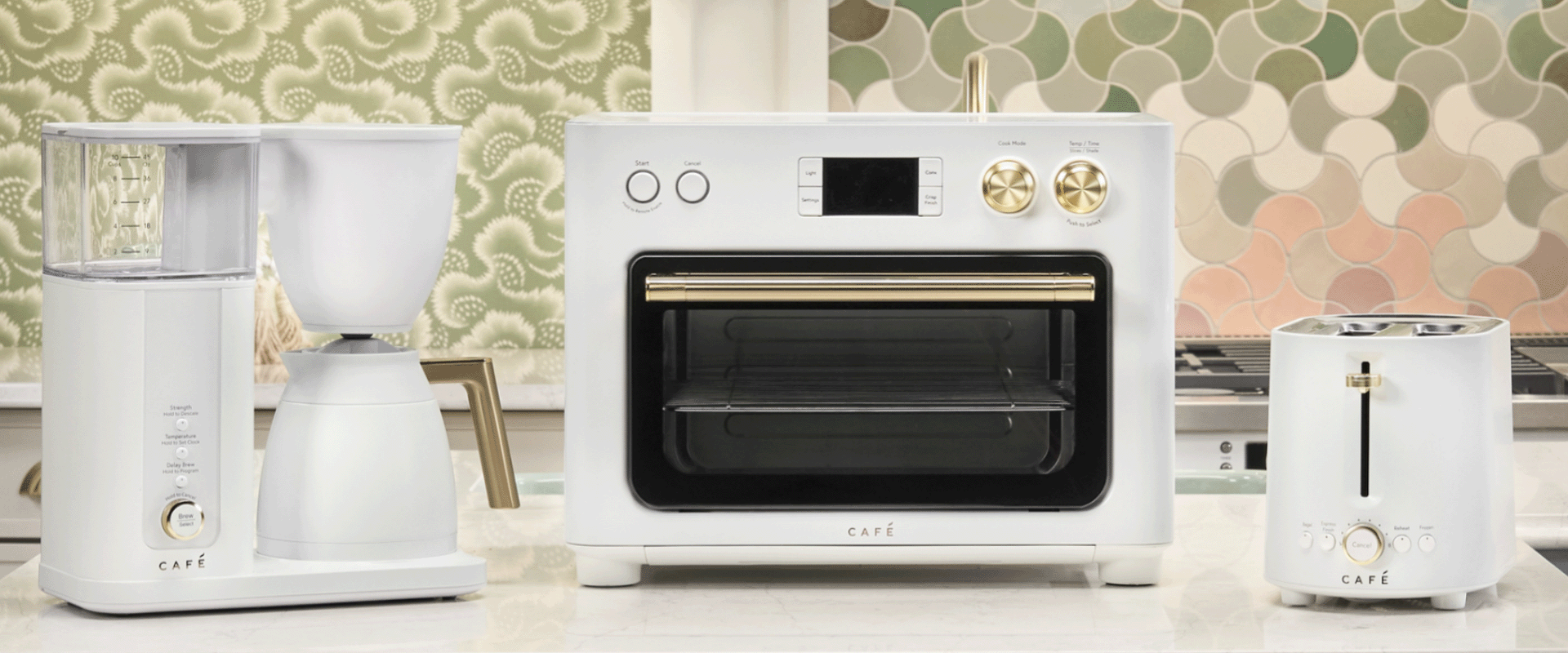 Coffee maker, toaster, and oven on a kitchen countertop with patterned background.
