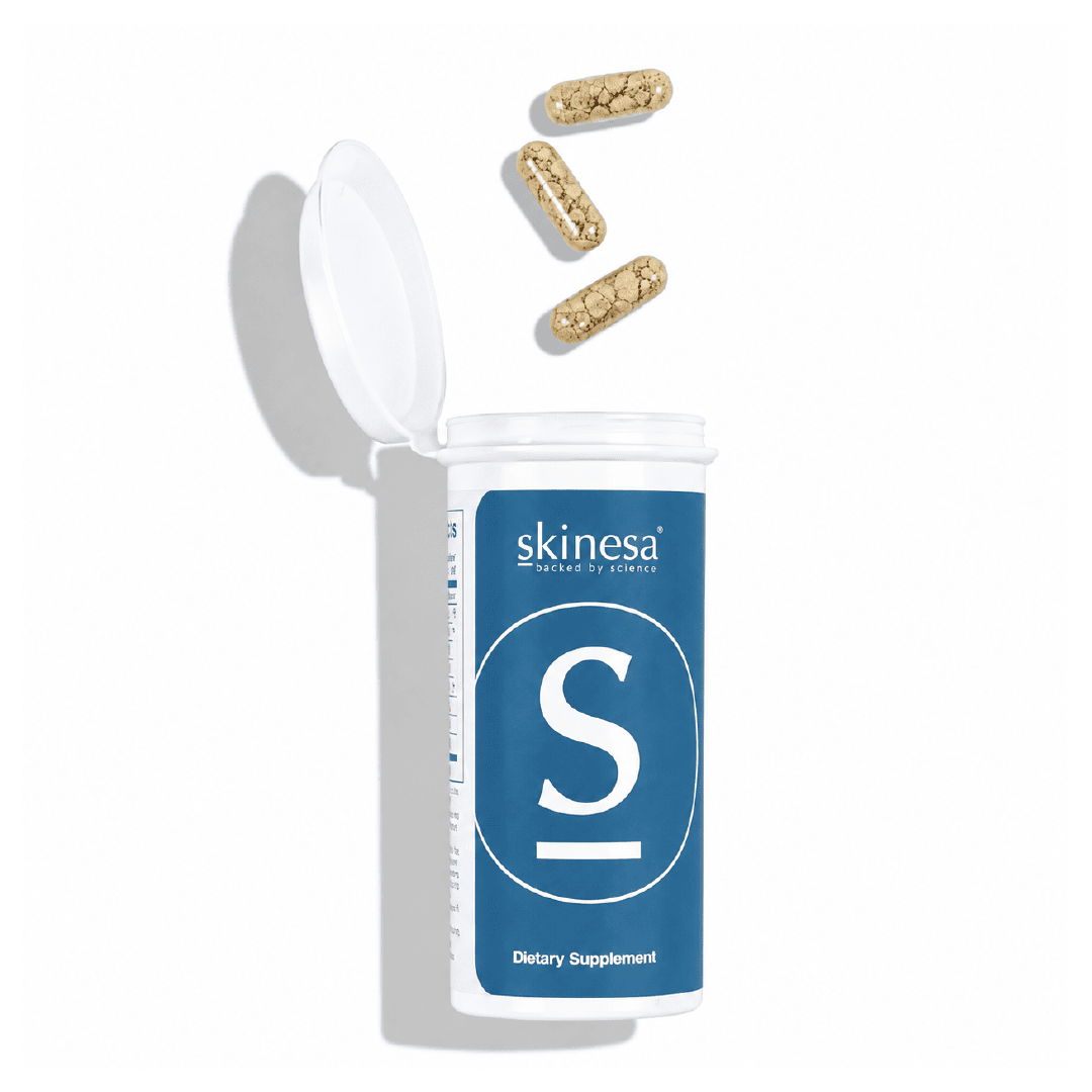 Bottle of dietary supplements with capsules spilling out.