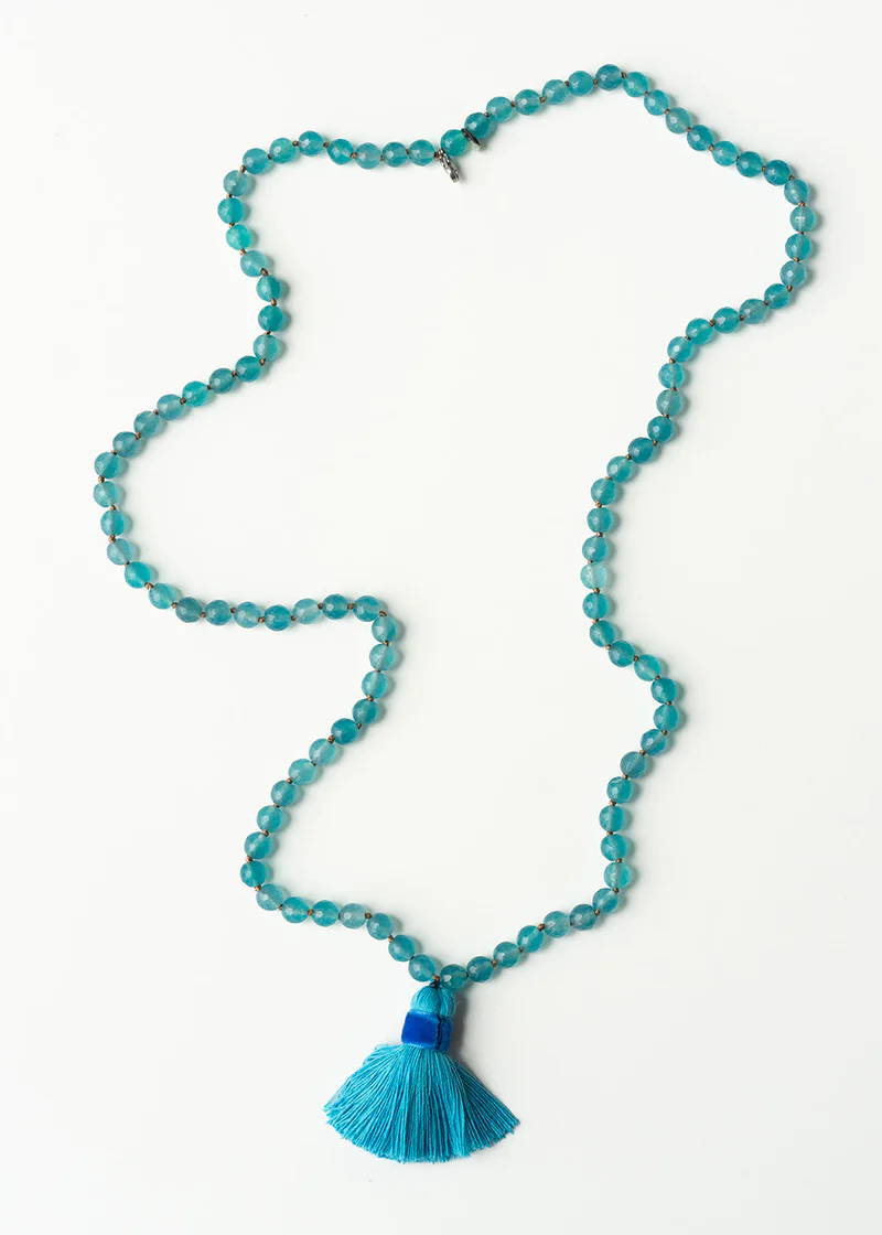 An aqua blue beaded necklace with matching tassle pendant