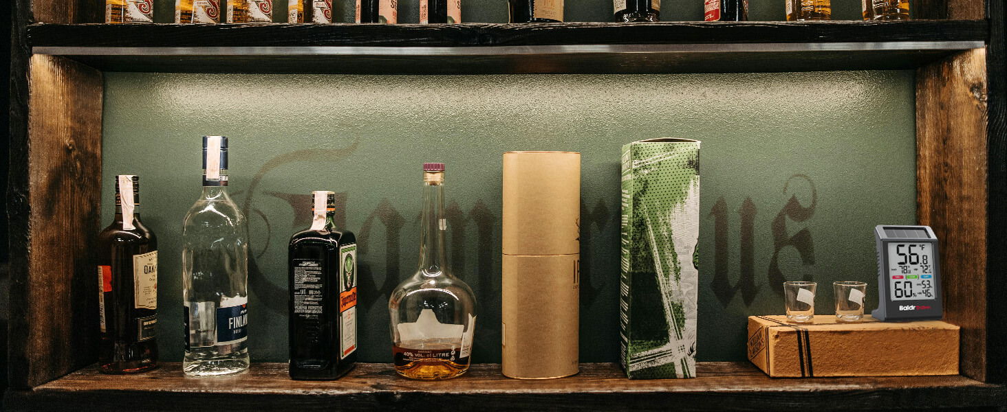 A shelf displaying various bottles of liquor and glassware.