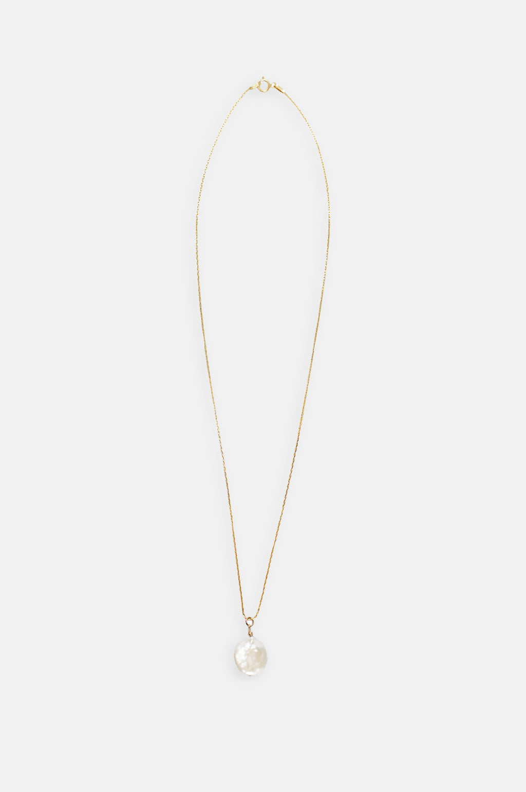 A product image of the Margaux Studios pearl drop necklace on a gold chain.