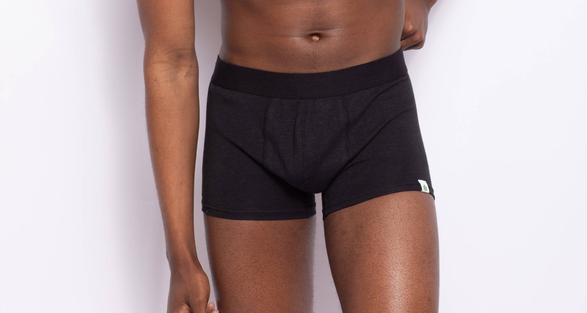 Close up of a man pulling up his black men’s trunks.