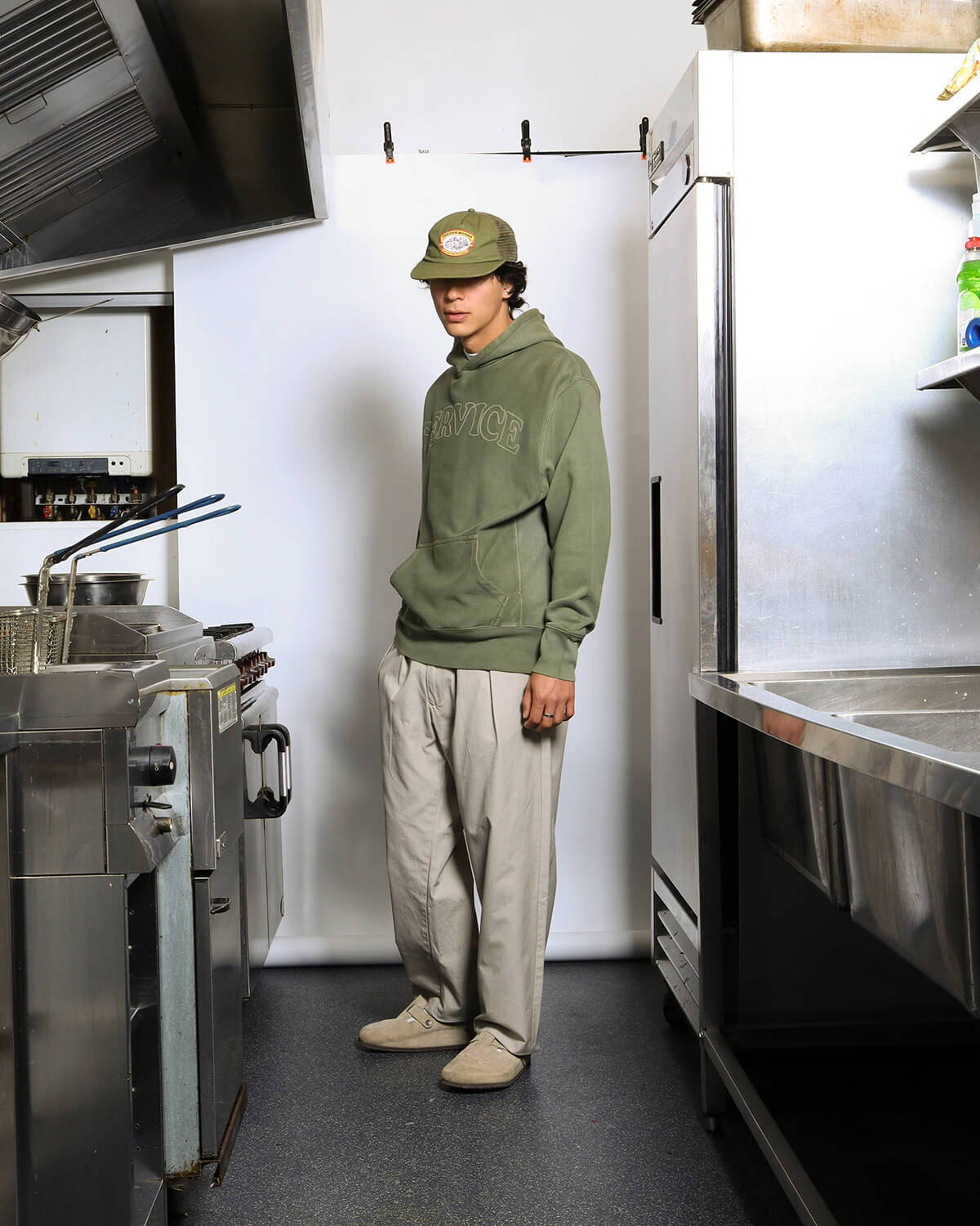 A look book image of a model wearing the Service Works Twill Part Timer Pant in stone.