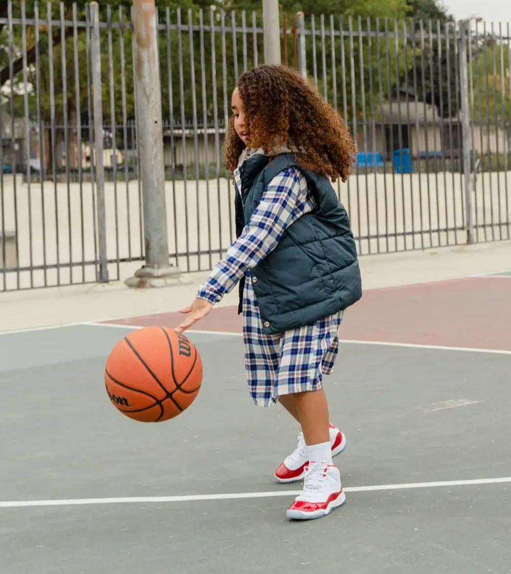 girl playing basketball with aj11 retro cherry