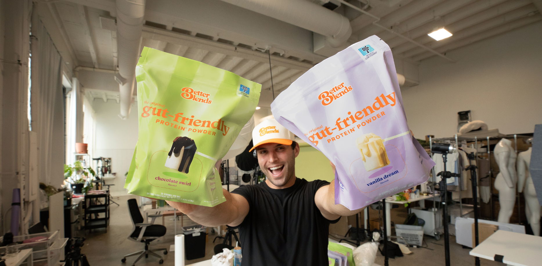 Better Blends founder John Redmond holding Chocolate Swirl and Vanilla Dream gut-friendly protein powder bags during a brand photoshoot.