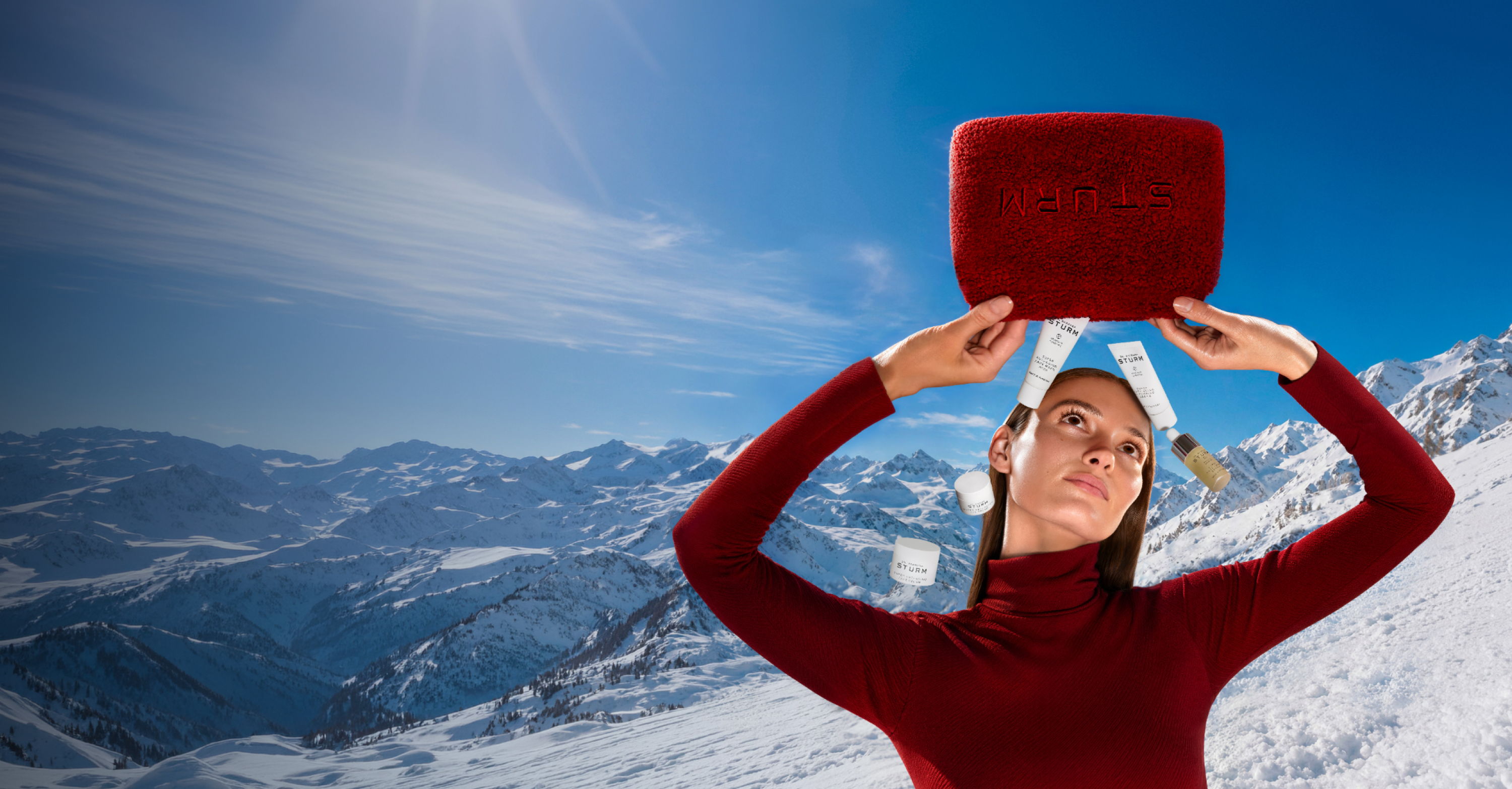 Person balancing a red object on their head in a snowy landscape.