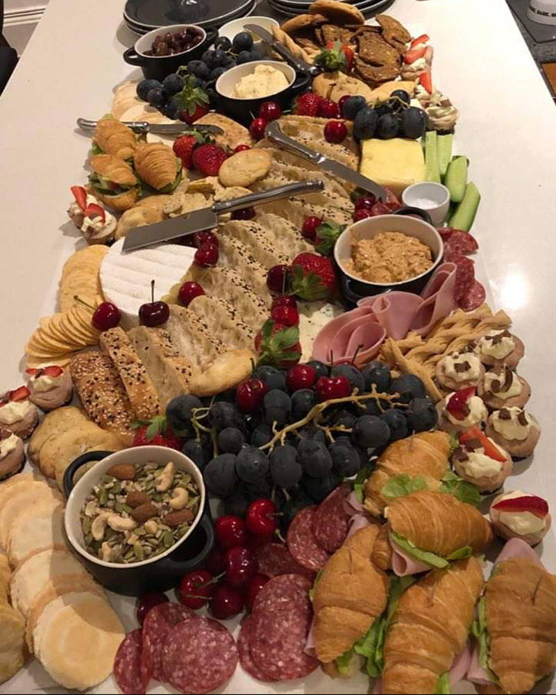 Cheese board with array of fruits, cheeses and meats.