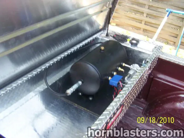 Air tank and train horn components mounted in truck bed toolbox