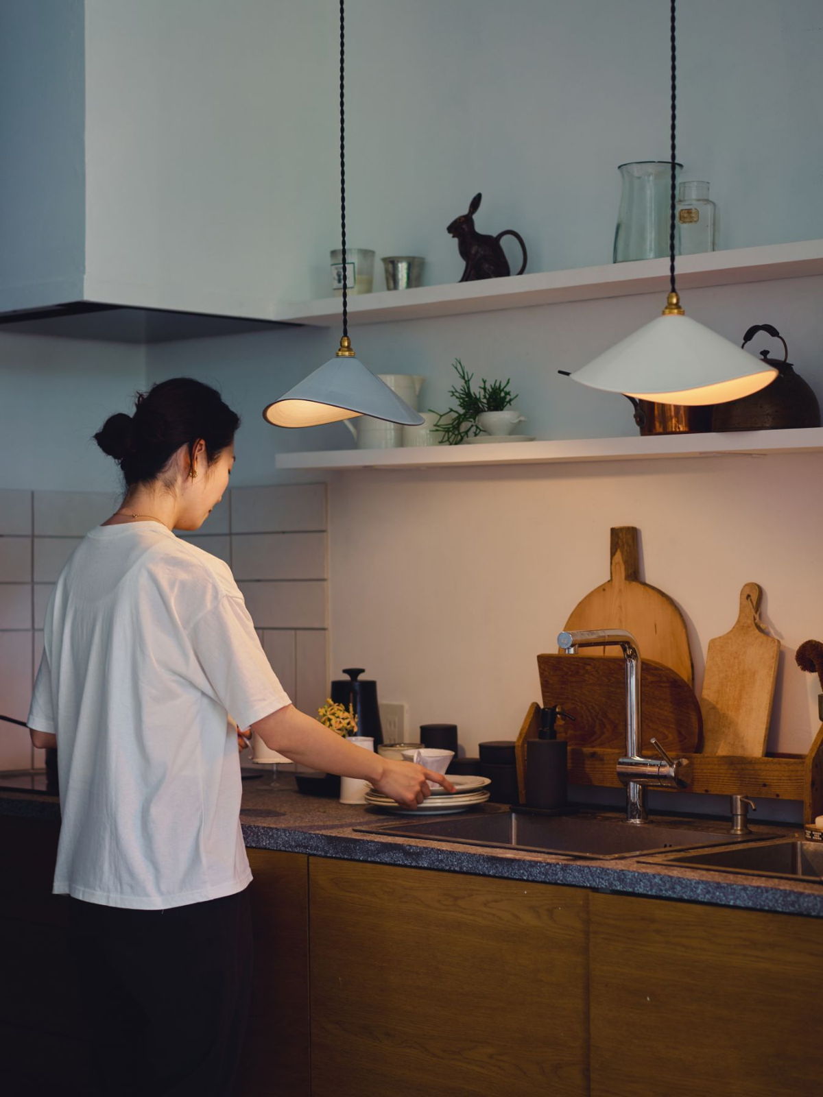A person preparing food in a modern kitchen with warm lighting.