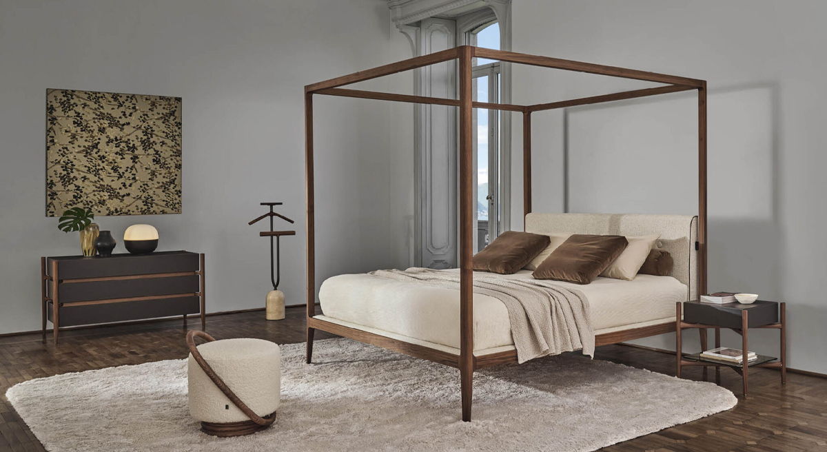 A modern Porada bedroom with a Ziggy four poster bed, nightstand, and decorative rug.