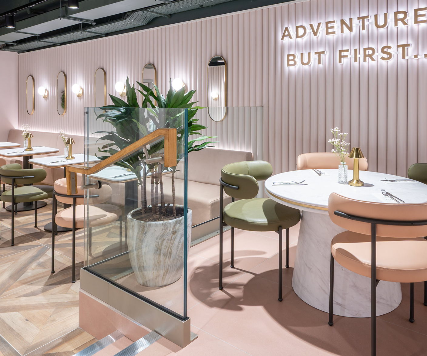 Modern restaurant interior with colorful chairs and decorative wall lighting.