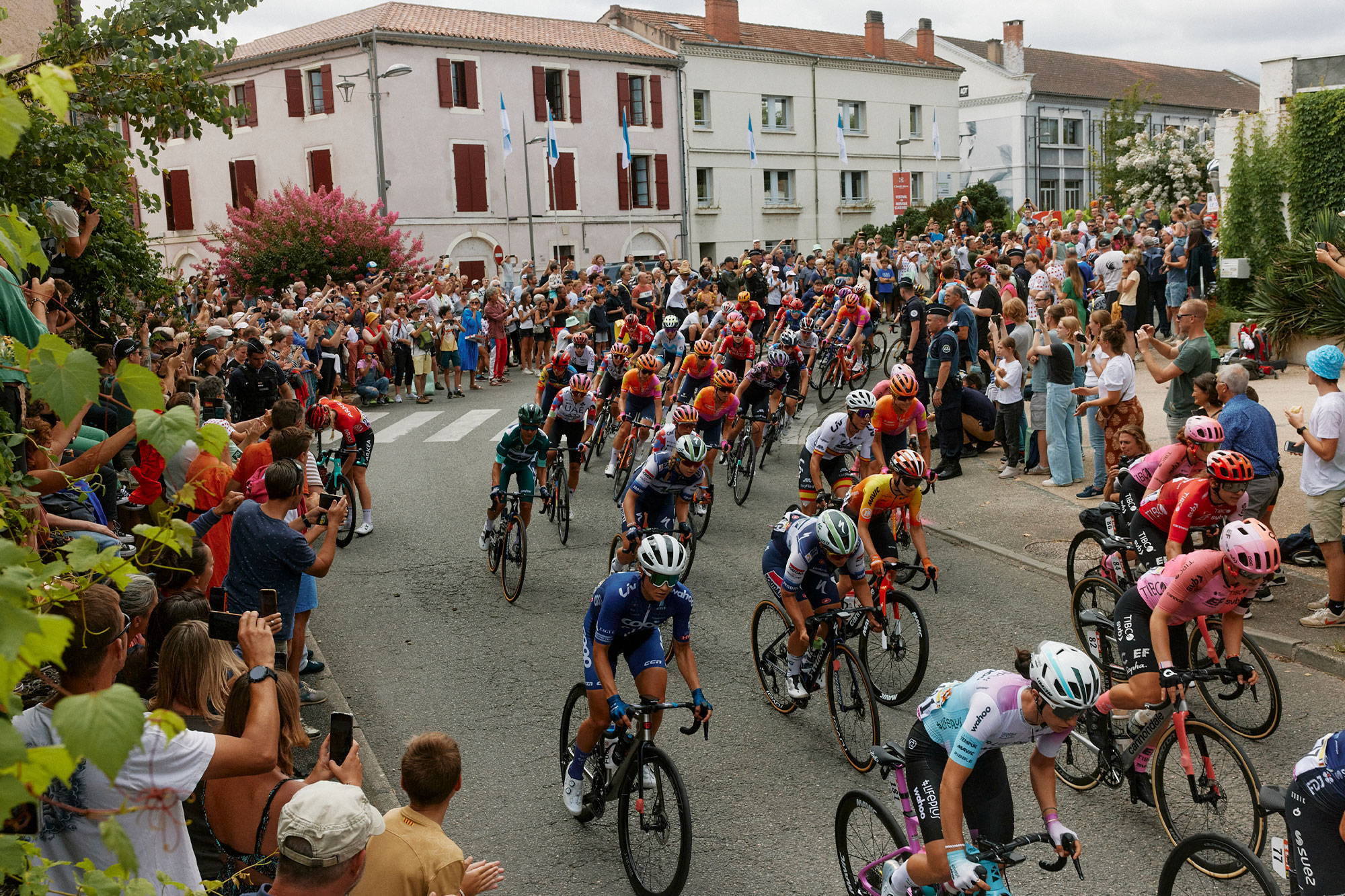 The peloton cornering through crowded village