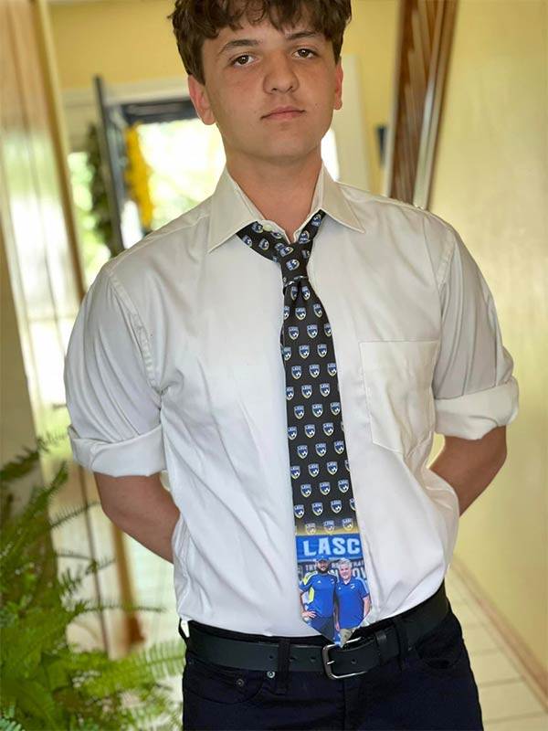 A teen wearing a white dress shirt with a custom soccer club necktie