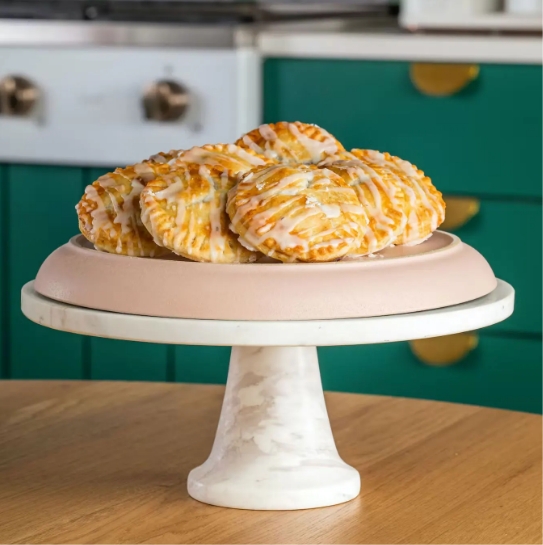 A cake stand with pastries on a wooden table.