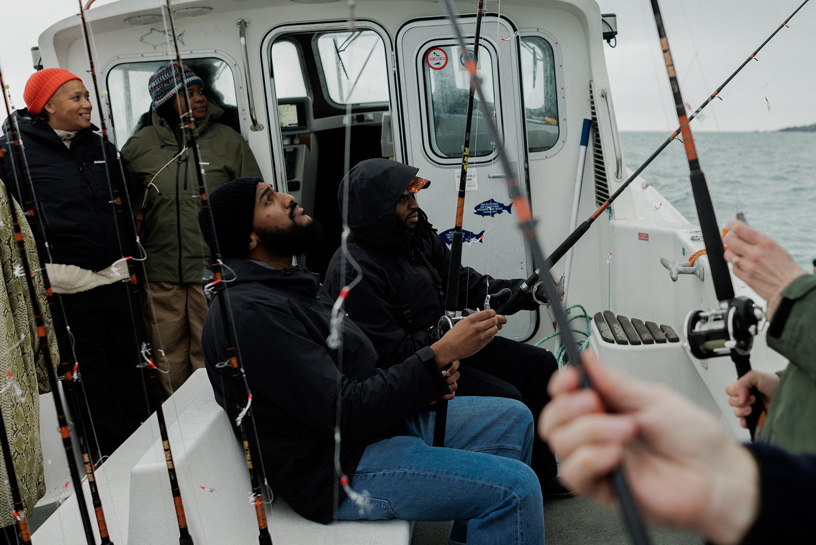 Group of people fishing on a boat in a cloudy environment.