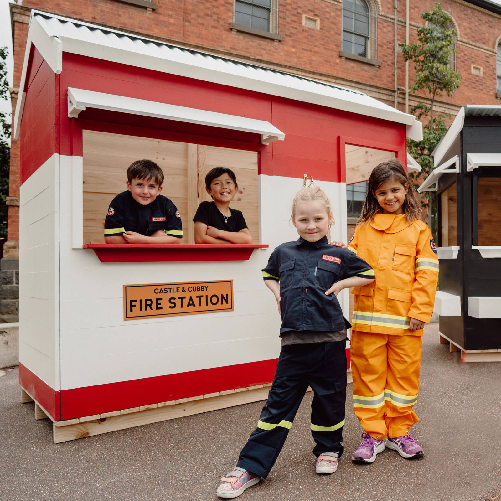 Children wearing firefighter's costume to play with a themed cubby house.
