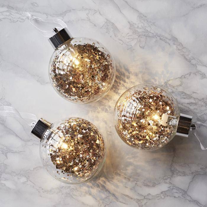 Trio of glitter baubles on table 