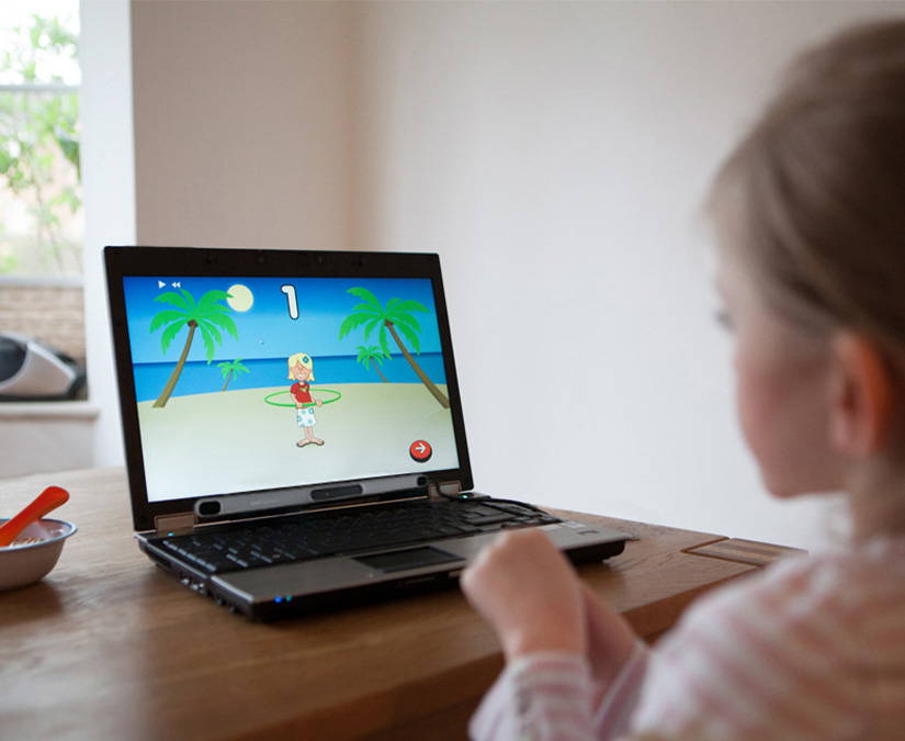 Une fille joue à un jeu avec ses yeux sur un ordinateur portable en utilisant le Tobii Dynavox PCEye