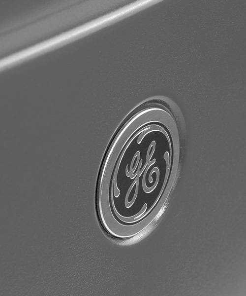 Closeup image of top of HVAC unit, showing the GE logo