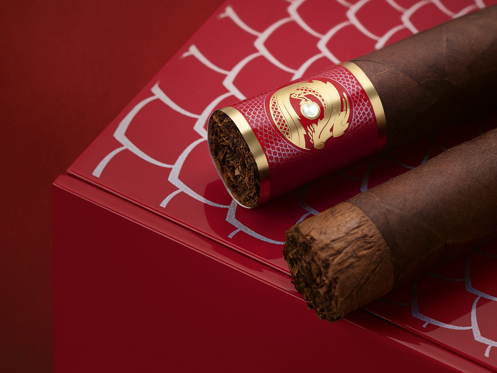 Two Davidoff Year of the Dragon Limited Edition Gran Toro cigars placed on the lid of their box.