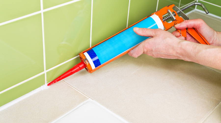 A person applying grout to a bathroom floor