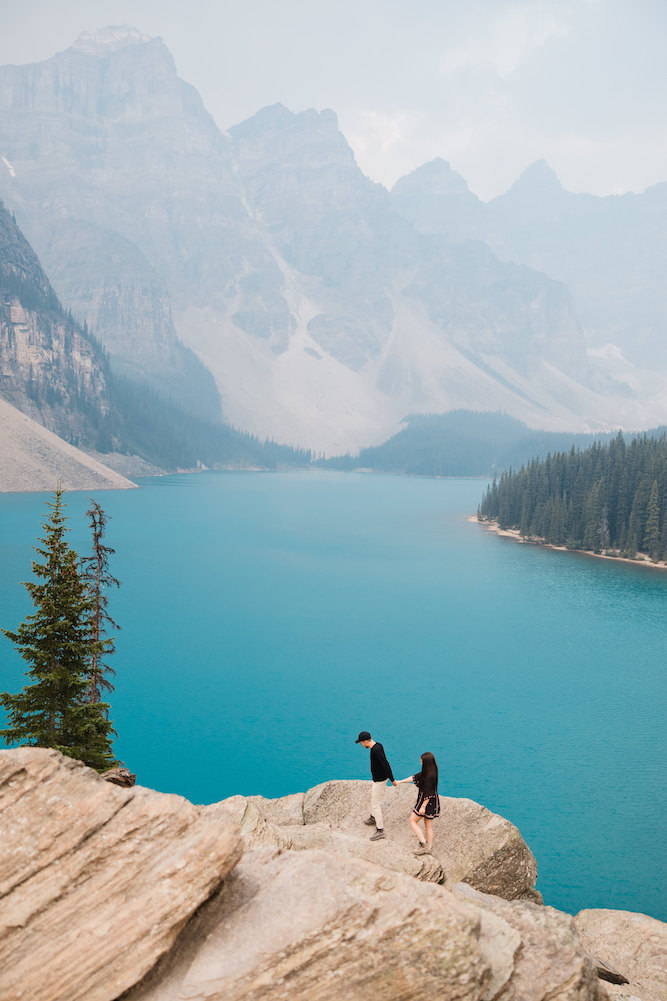 couple hiking with moraine lake in background