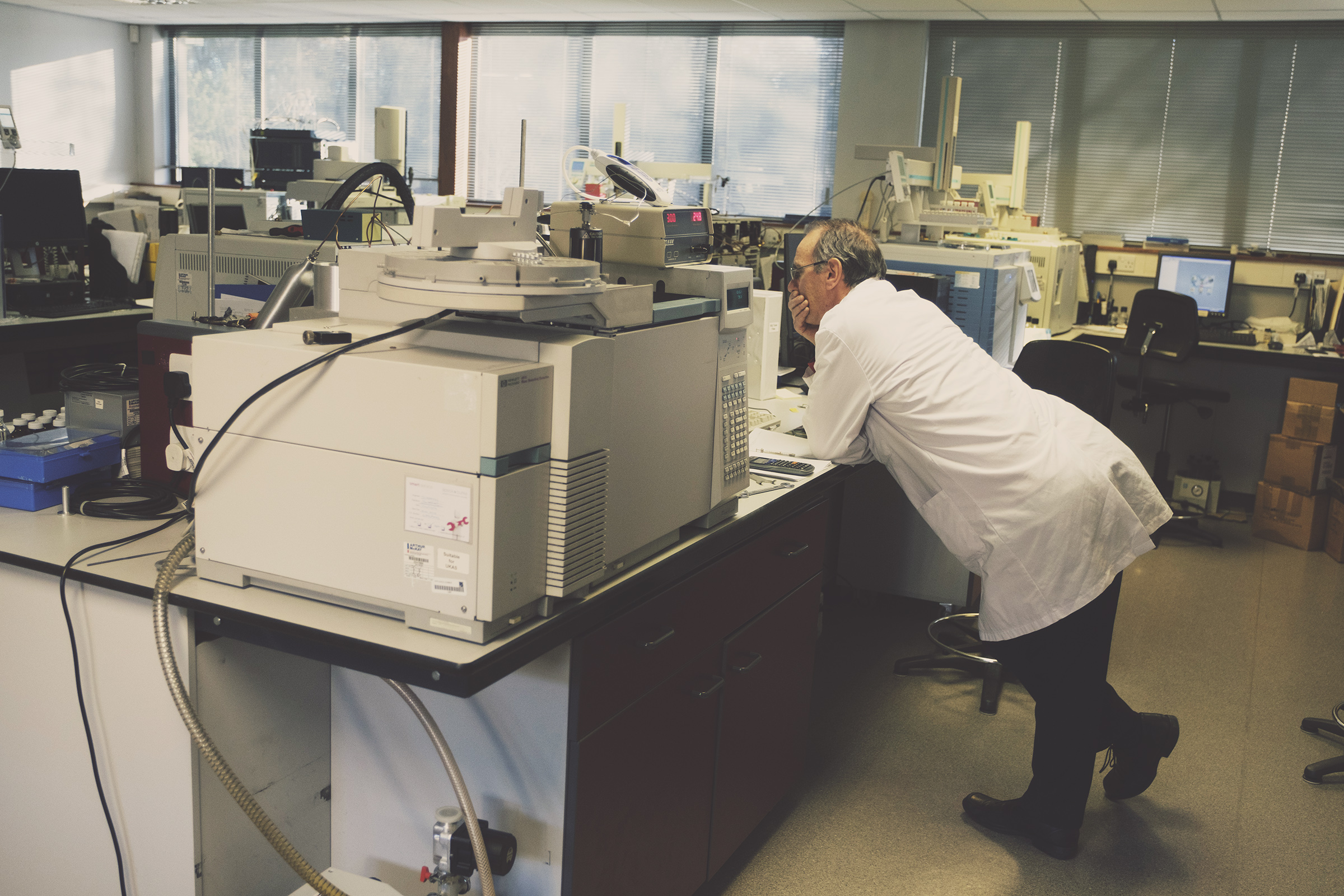 A scientist working in a laboratory with equipment on a counter.