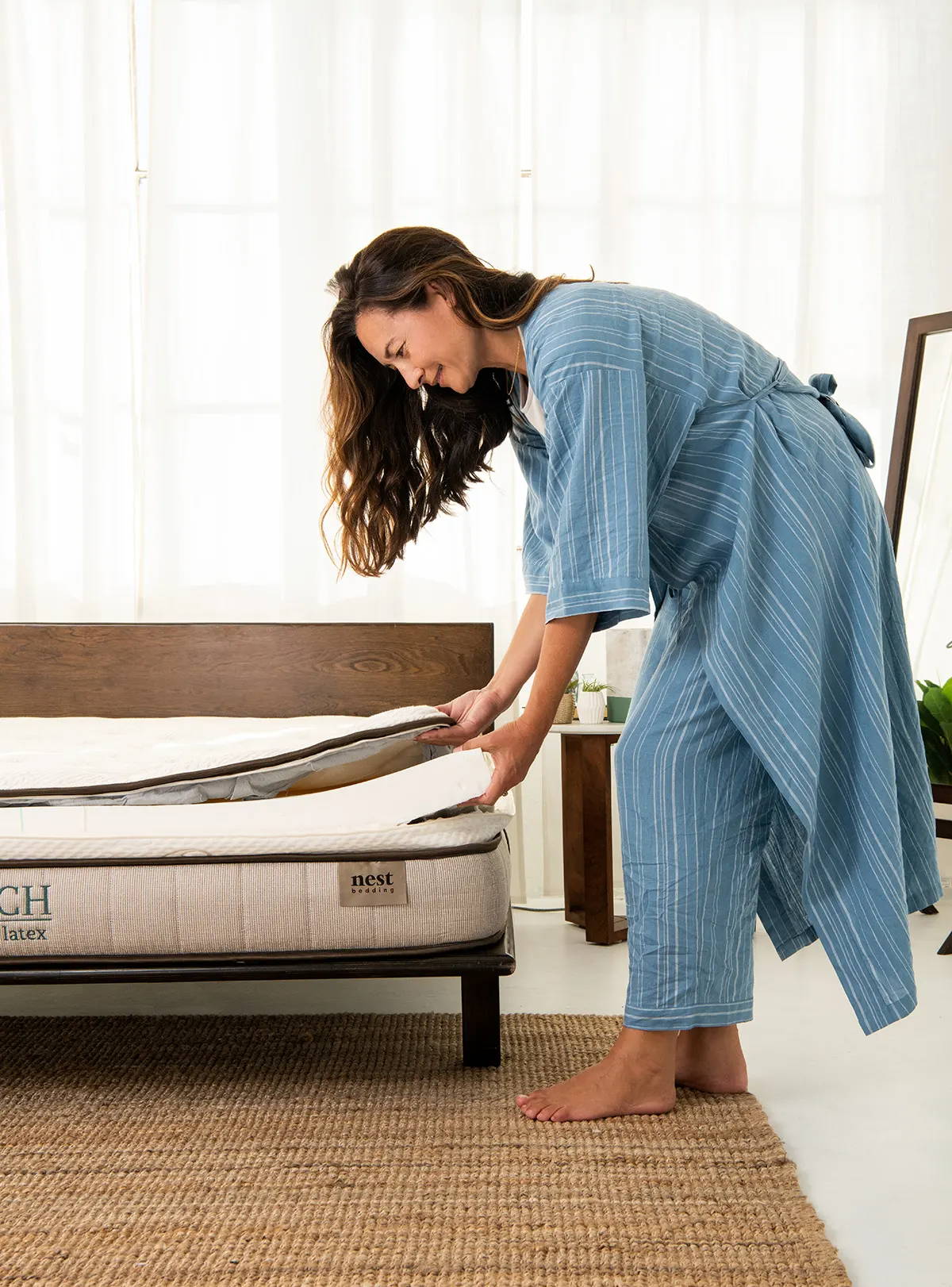 a woman lifting the natural latex comfort layer from an unzipped finch natural latex mattress