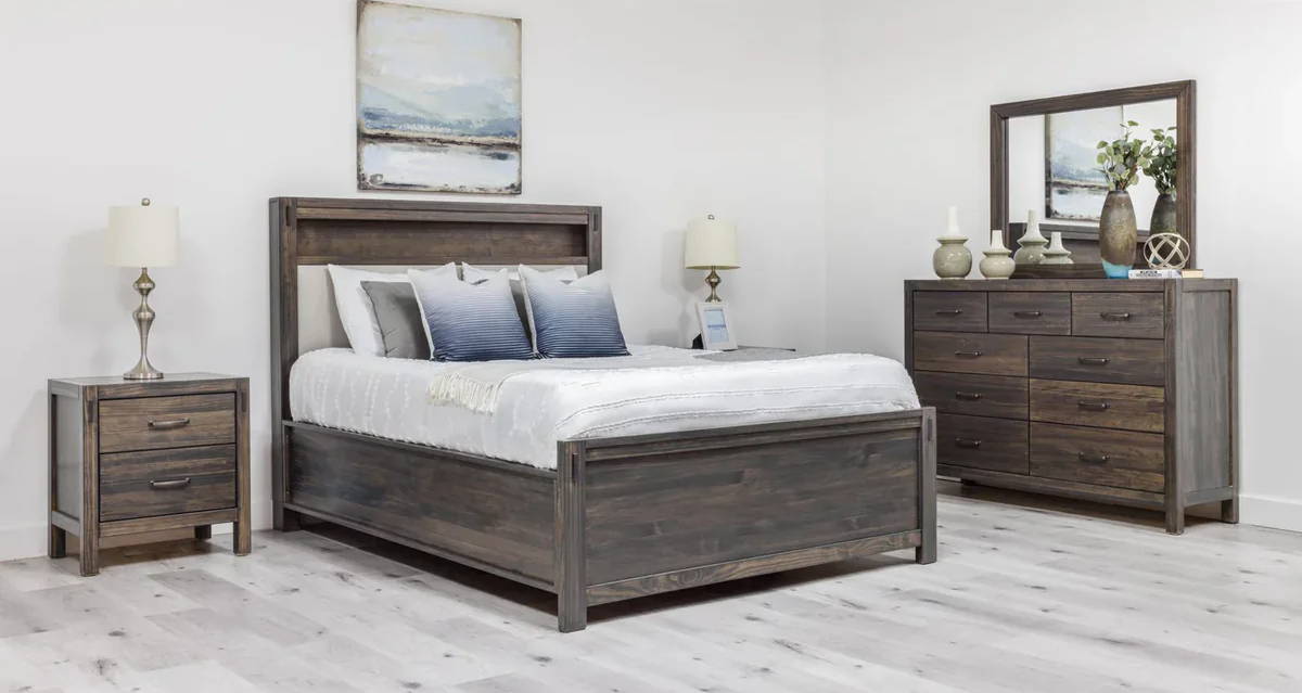 Bedroom with wooden furniture: bed, nightstand, dresser, and mirror.