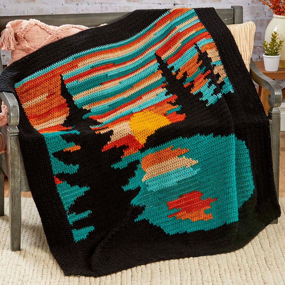 Colorful graphgan blanket with a sunset and trees design.