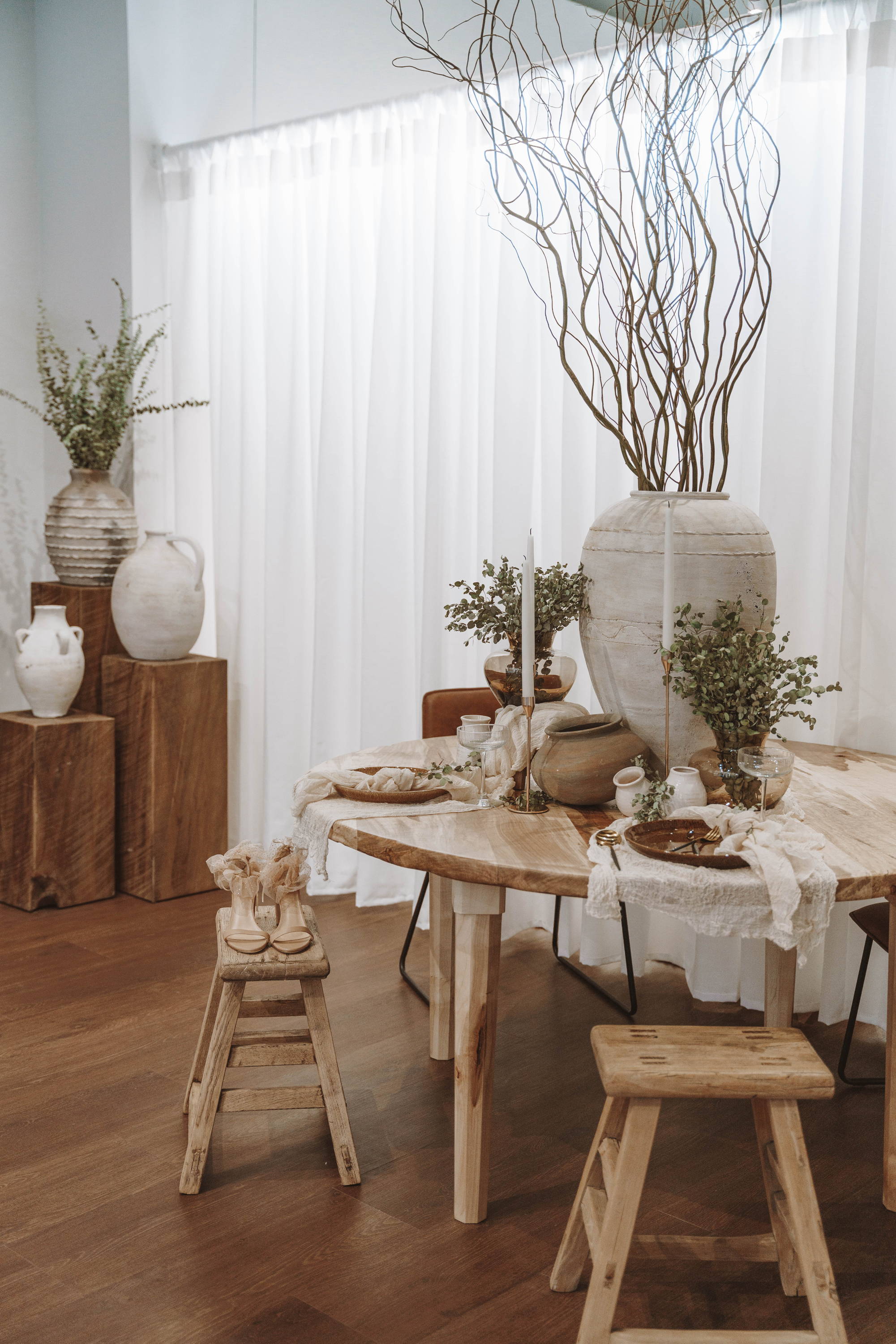 Pots en céramique et tabourets en bois à une table circulaire 