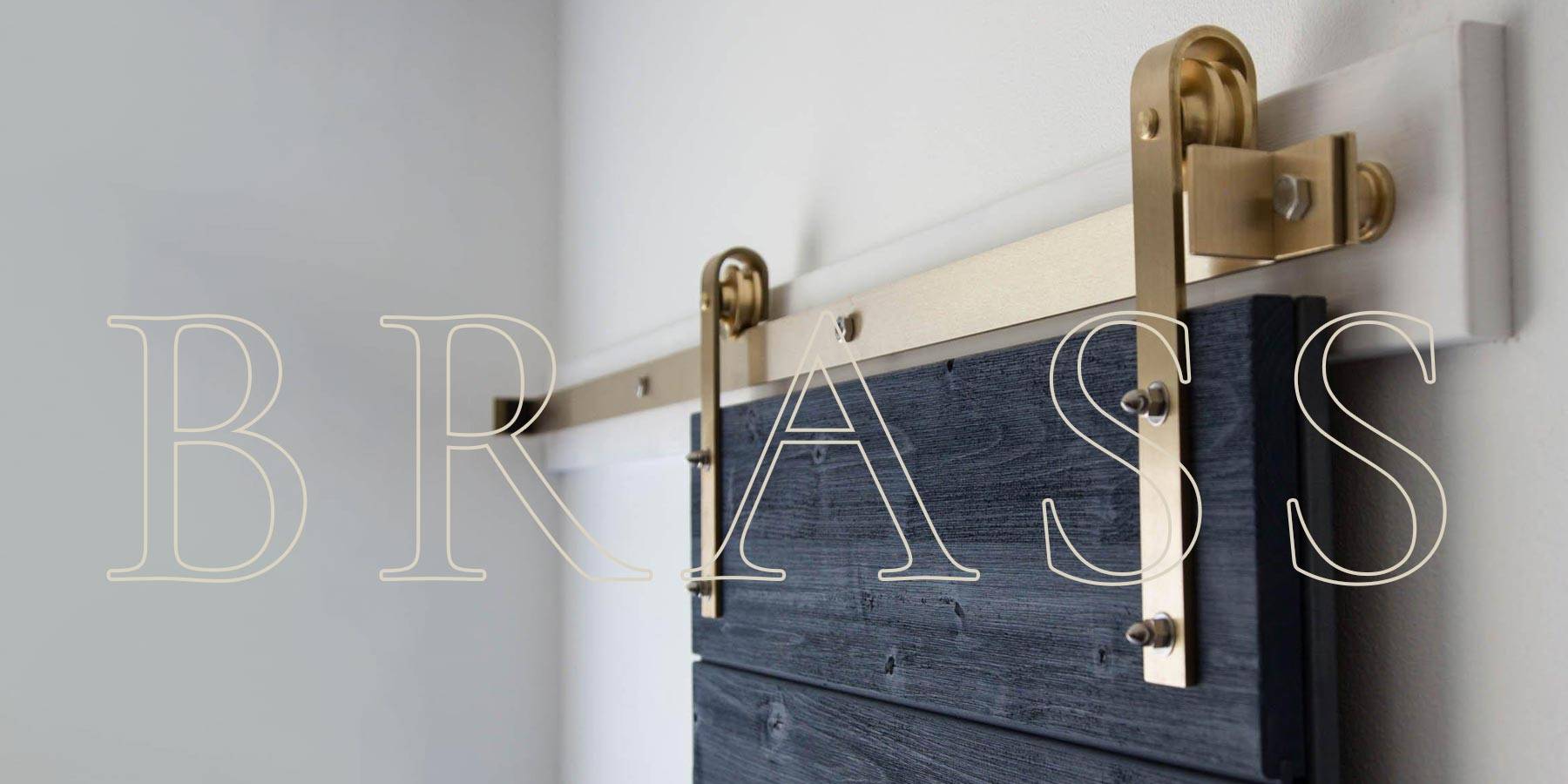 Classic Flat Track Barn Door Hardware installed on a blue barn door. The word BRASS is writtern over the image.
