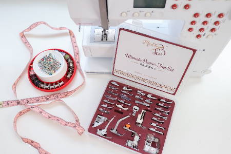 the ultimate presser foot set in front of a sewing machine with a tape measure and magnetic pincushion