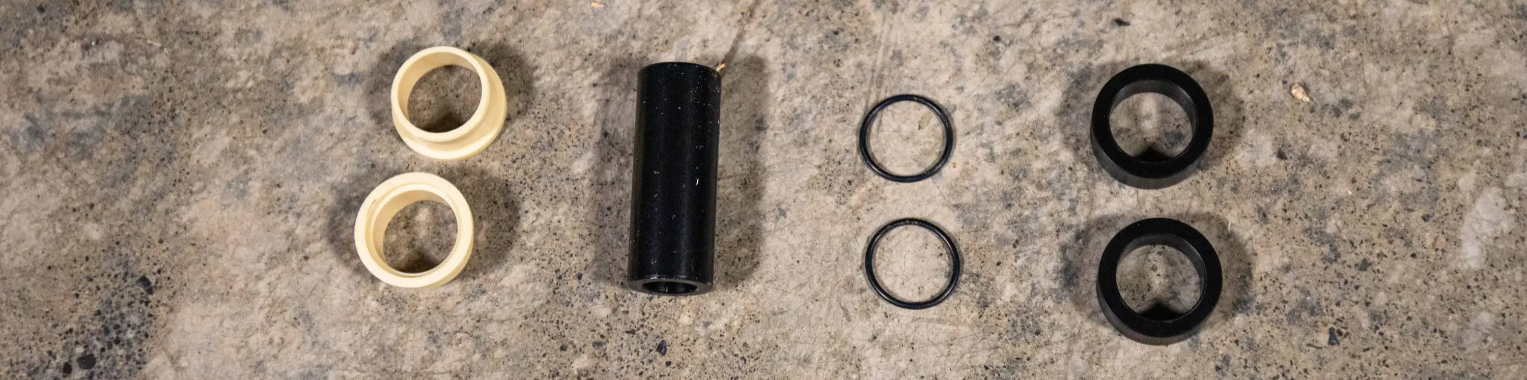 Mountain Bike Rear Shock Mounting hardware components layed out on the floor