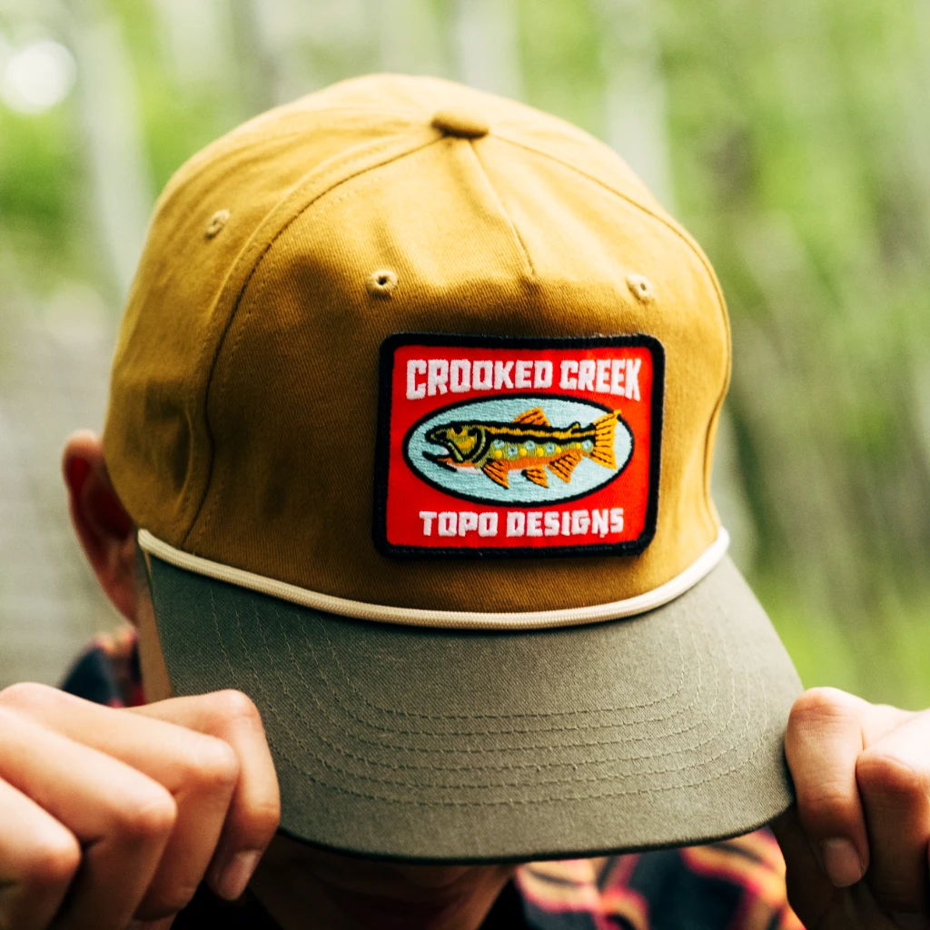 A person wearing a yellow hat with a colorful patch.