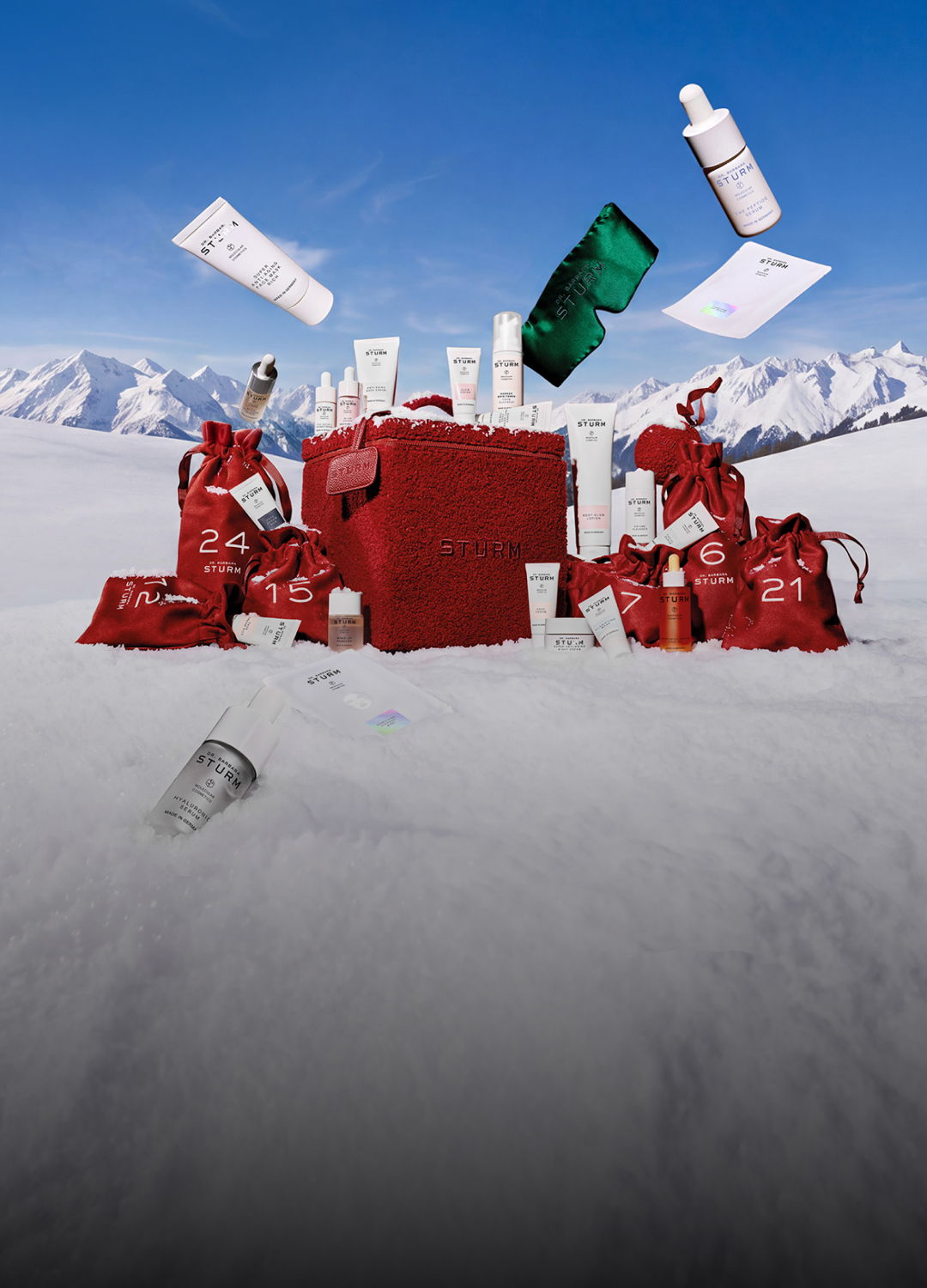 A collection of cosmetic products arranged around a gift box in snow.